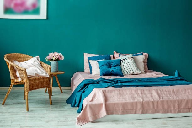 A bed with pink and blue pillows

AI-generated content may be incorrect.